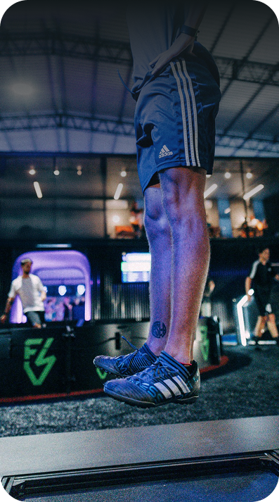A person wearing blue Adidas running shoes and matching blue shorts with white stripes, captured mid-jump on esa apex 