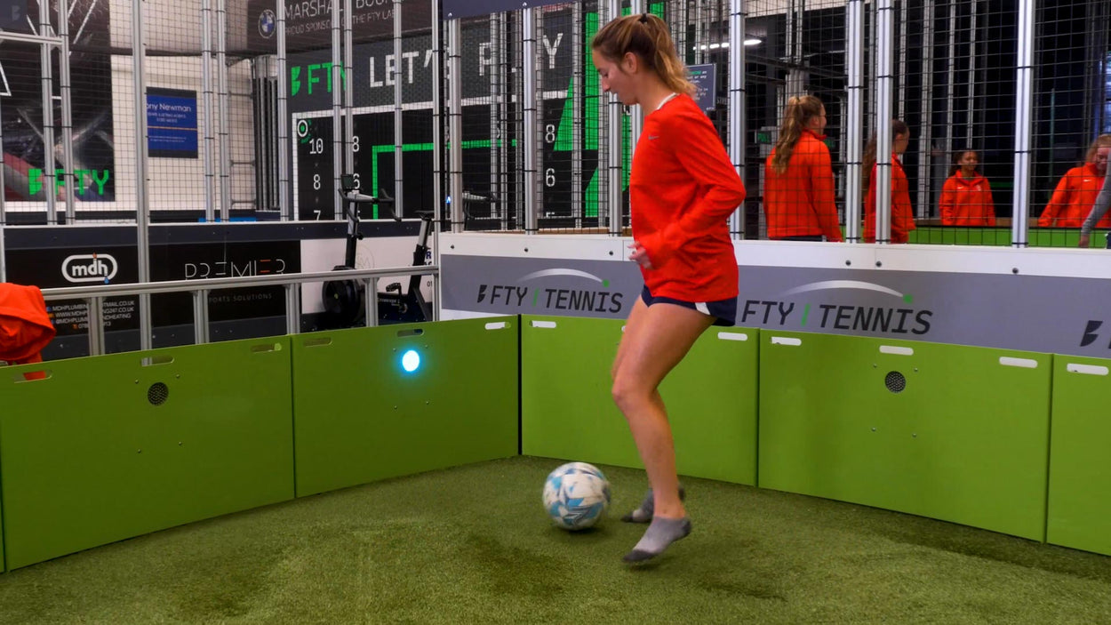 girl dribbling football inside acura elite icon cube 12 panel