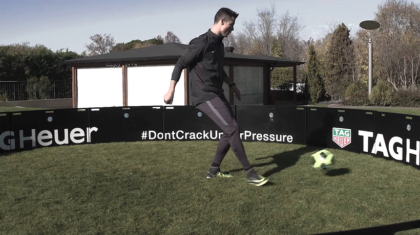 Cristiano Ronaldo wearing black tracksuit while kicking ball at acura elite icon arena 6m outside with trees in background 
