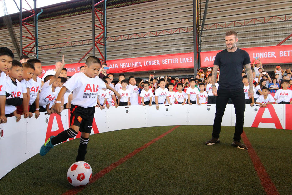 Young boy playing soccer/football inside icon arena with david beckham and crows d watching