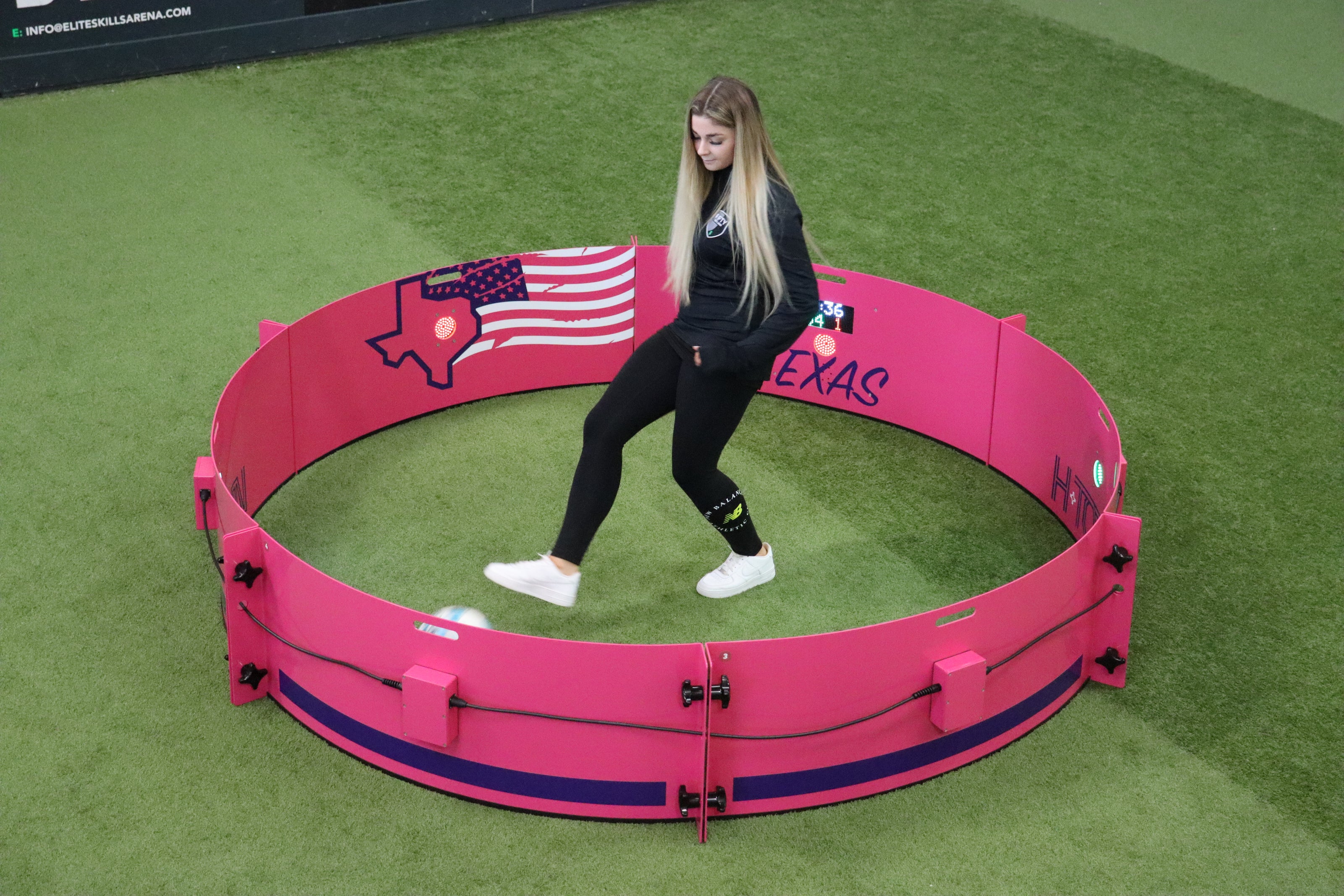 girl playing football in acura elite icon fast feet with pink texas branding