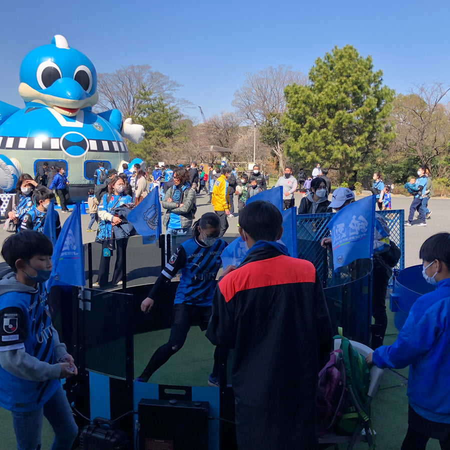 festival with kids playing football inside acura elite icon fast feet with inflatable blue mascot in background