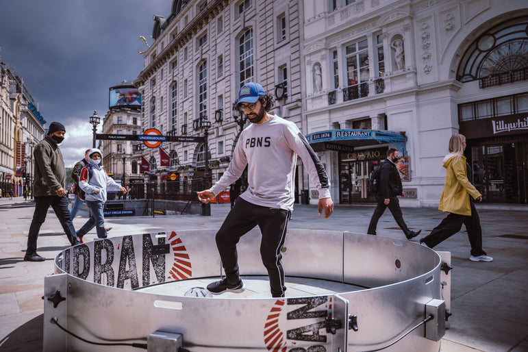 Man in Picadilly outside london underground using football acura icon fast feet with urban branding
