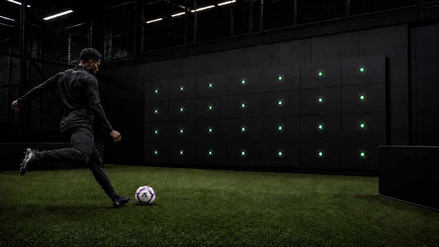 man kicking acura ball at elite sports arena precision wall