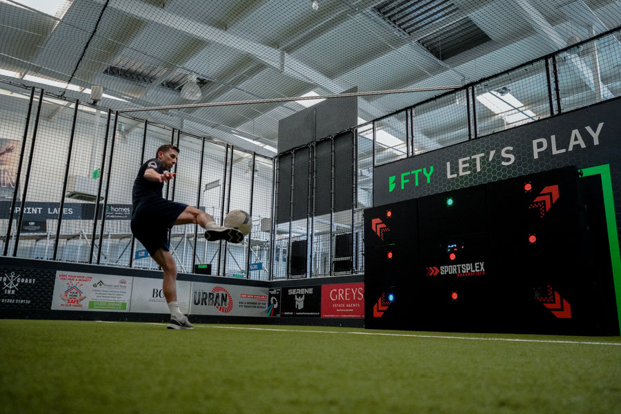 man kicking ball at precision wall 9 panel on grass