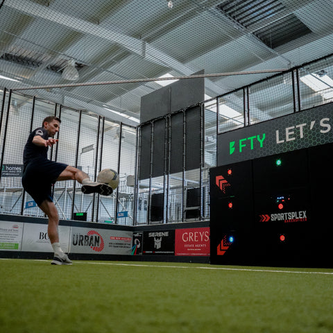 Person playing indoor football with acura 9-panel precision wall