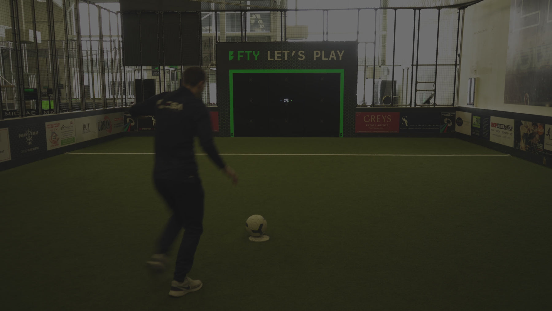 video of man demonstrating how noughts and crosses game mode works on acura elite precision wall inside training facility with astro turf